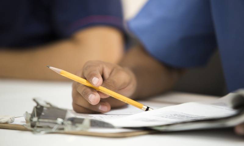 A man tapping a pencil as they take a test.