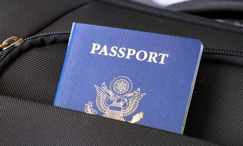 A US Passport peeking out of a bag compartment.